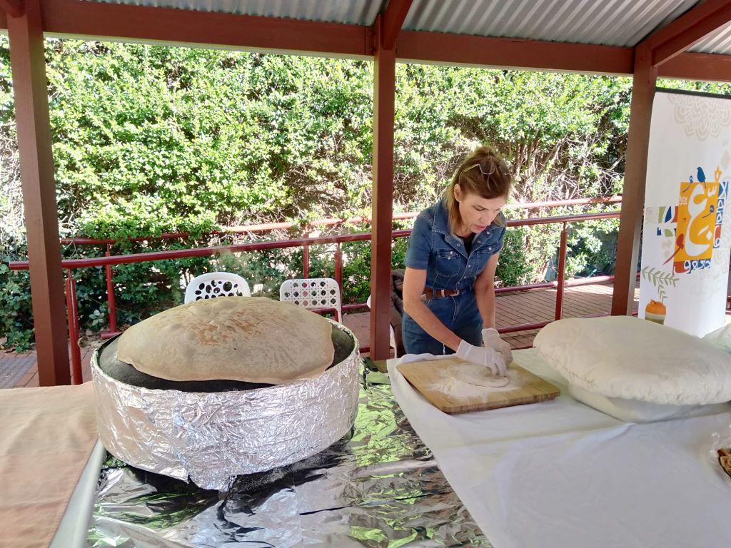 Nayfeh turning the dough into a flat round bread
