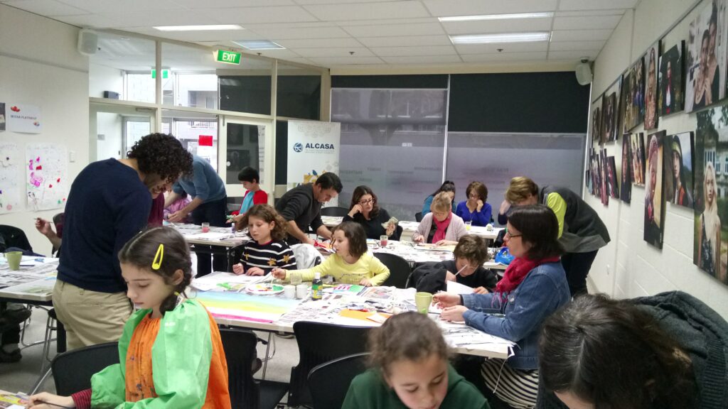 A group of young children and adults engaged in drawing and painting